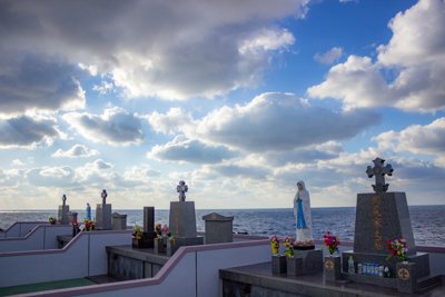 五島列島、青い海と空に抱かれた祈りのマリア像と墓地