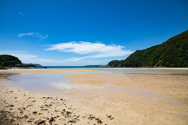 干潟が広がるビーチとエメラルドグリーンの頓泊海水浴場