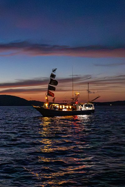 宇久島・竜神祭（ひよひよ祭）夕焼けの海に浮かぶ大漁旗の漁船