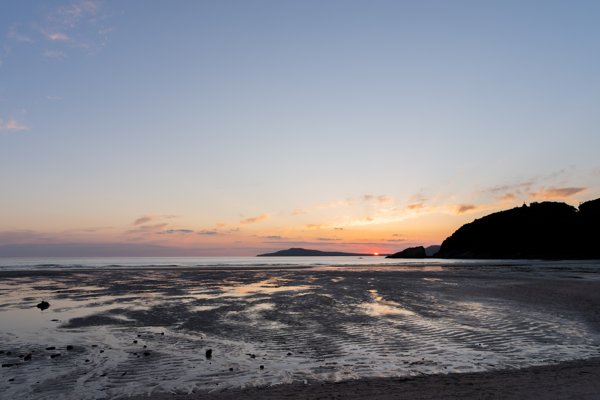 干潟に映る夕焼け空と水平線