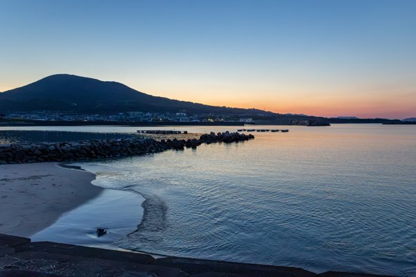 五島市崎山地区の白浜海岸。夕焼けと港に広がる静かな海