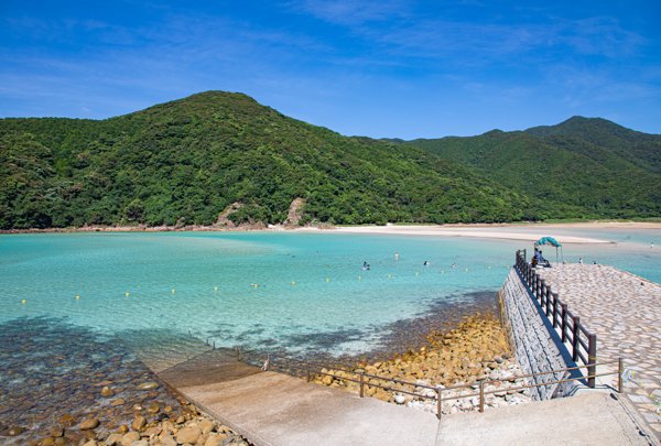 青い海と緑の山々、桟橋のある頓泊海水浴場