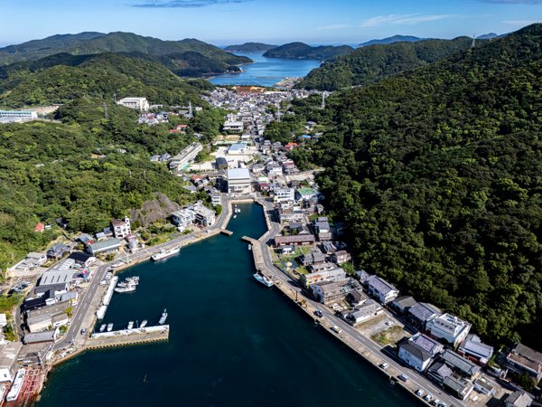 奈留島の港町と山々に囲まれた集落の空撮風景